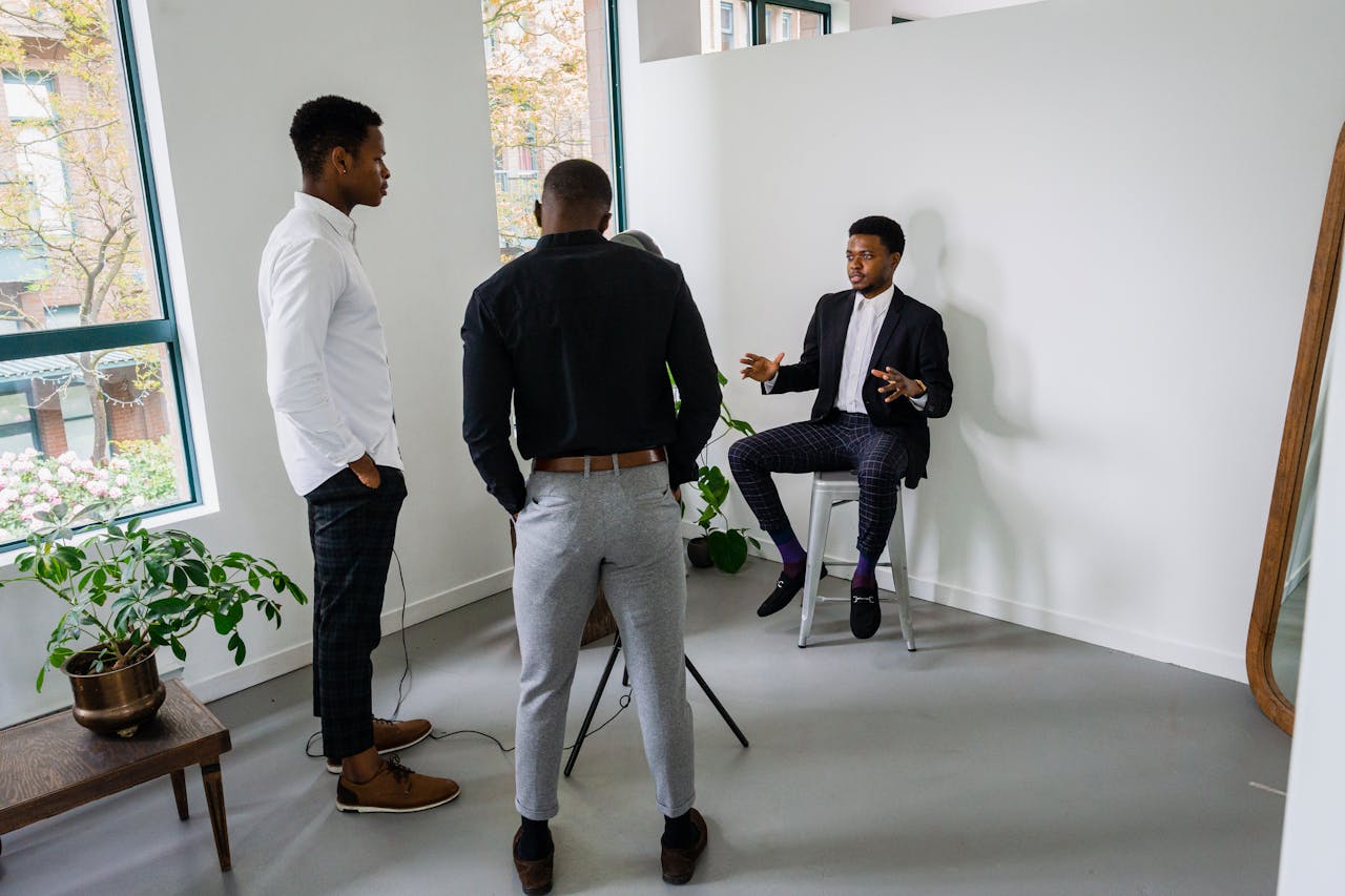 Three businessmen engaged in a meeting in a bright office space, discussing strategy.